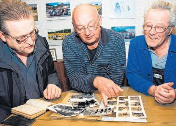Alte Fotos der Feuerwehr Weitefeld nehmen hier (v.l.) die Kameraden Karl-Heinz Keßler, Klaus Kirchhöfer und Detlef Flug in Augenschein.